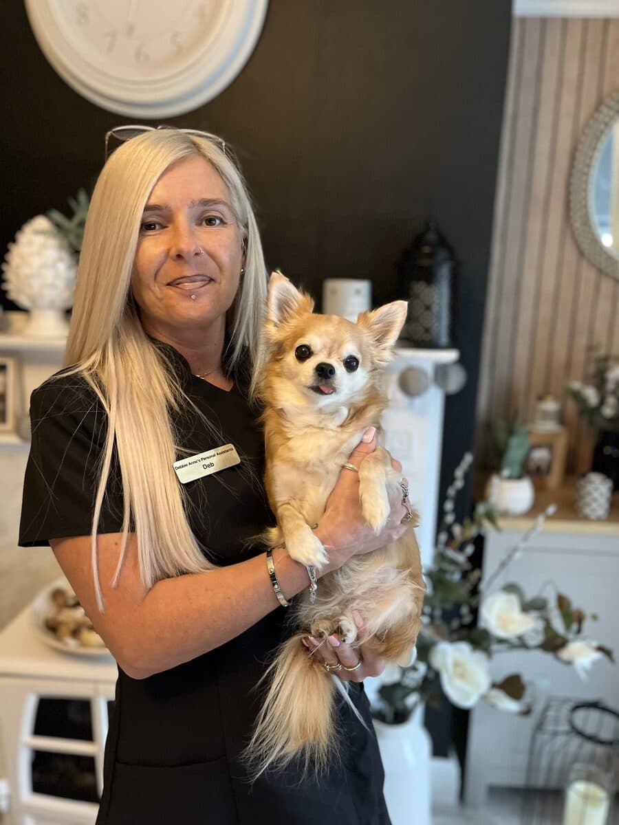 Deb of Debbie Anne’s Personal Assistants, in her work uniform, holding her chihuahua