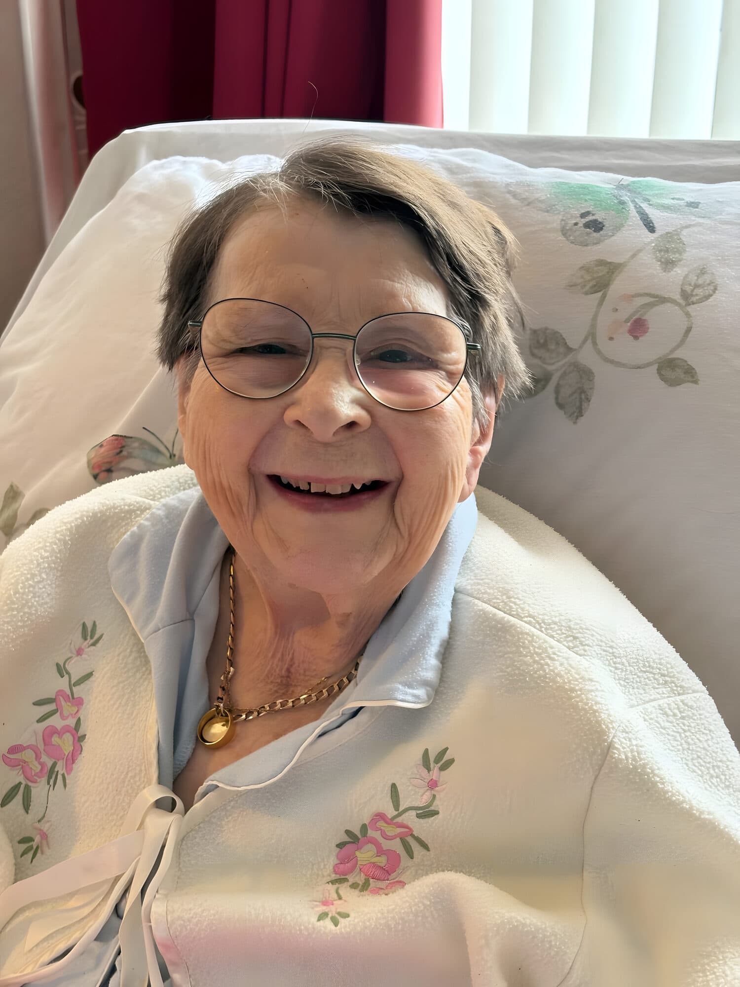 A Debbie Anne's client smiling from her bed at home